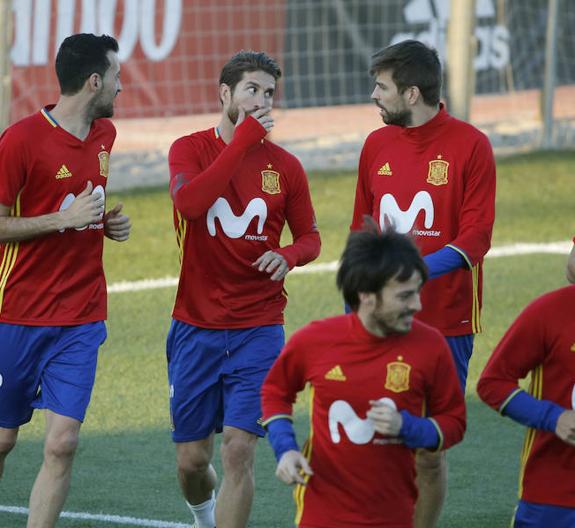 Ramos habla con su compañero Pique en la sesión de ayer. 