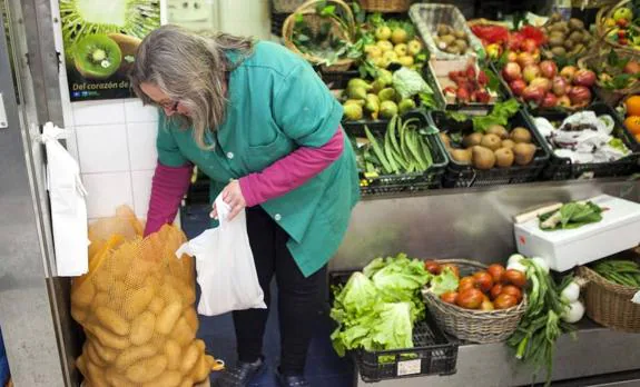 María Tuero vende patata a granel en su puesto del Mercado del Sur de Gijón. 