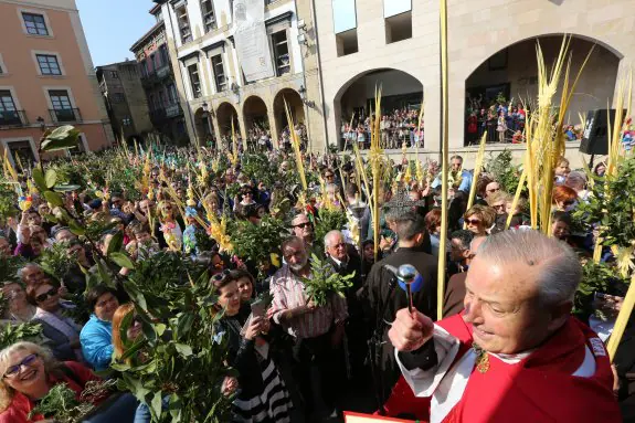 Los feligreses abarrotaron la plaza de Carlos Lobo en la bendición de ramos realizada por el párroco Ángel Llano, previa al inicio de la procesión de La Borriquilla. 