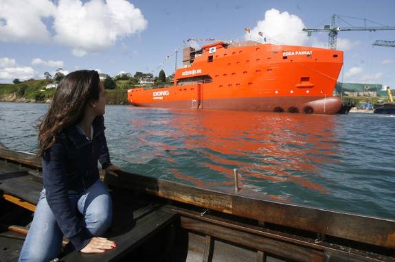 Una joven observa el Edda Passat, el buque recién botado por Gondán, desde la Ría del Eo. 