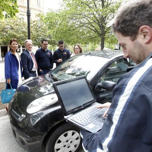 Manuel Fernández revisa su ordenador junto al coche que tomará las mediciones lumínicas, observado por Lada Strelnikova, directora del fondo europeo, y Rafael Gil, gerente de Soningeo Energy. 
