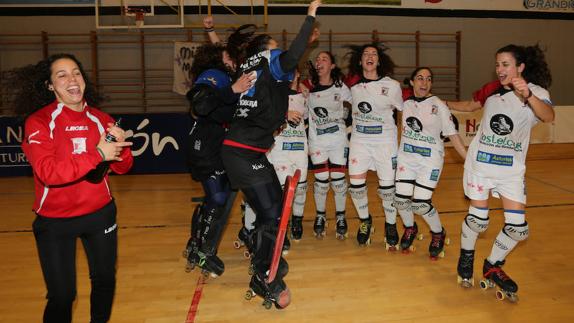 María Fernández ‘Pulgui’, entrenadora del Hostelcur, descorcha una botella de champán mientras sus jugadoras se abrazan al finalizar el encuentro. 