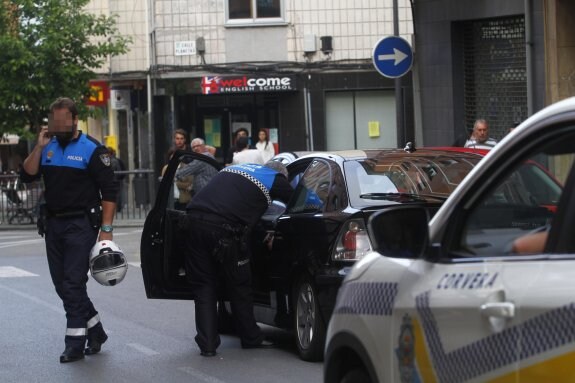 Los agentes de la Policía Local de Oviedo inspeccionan el coche en la calle Jovellanos de Las Vegas. 