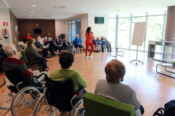 Una monitora del geriátrico de Felechosa dirige una actividad con varios de los residentes. 