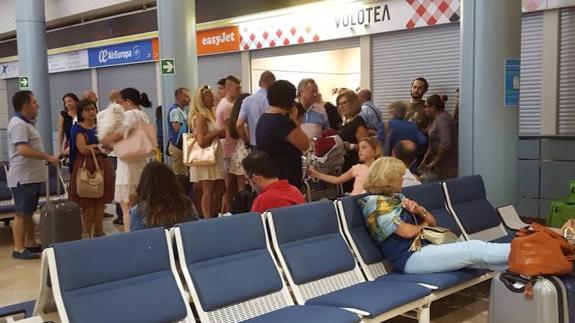 Los pasajeros apostados en el mostrador de Volotea tras decirles que les recolocarán mañana en otro vuelo.