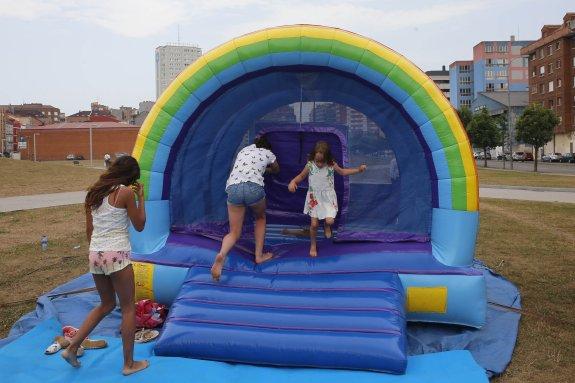 Tres niñas juegan en el arcoíris hinchable del 'solarón'. 