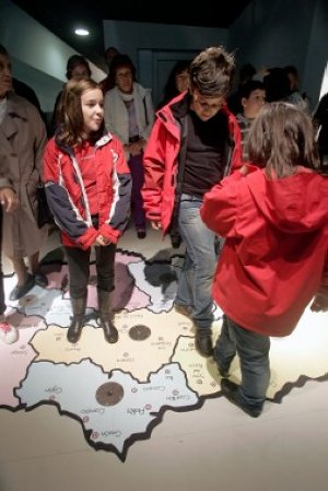 Un grupo de niños pisan un mapa de Asturias dividivo por comarcas. / P. CITOULA