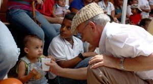 Aníbal Nieto da un vaso con agua a un niño en una escuela en Durán, en la nueva diócesis. ::
LVA