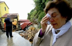 La cocinera del Molín del Puerto, Ilda Álvarez Álvarez, se seca las lágrimas ante los restos del establecimiento. ::                             MARIETA