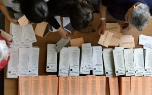 Un grupo de electores elige su papeleta en un proceso electoral. ::                             E. C.