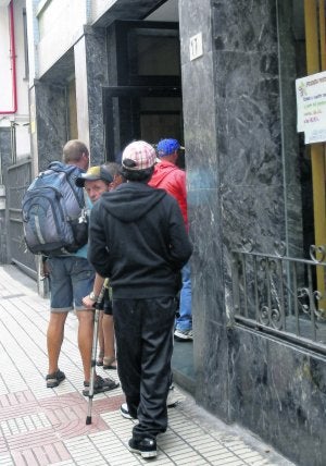 Varios usuarios entran en la Cocina Económica que en Gijón regenta la Asociación de Caridad. ::                             J. SIMAL