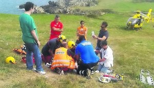 Los servicios sanitarios atienden a Félix Vázquez Ortiz en un prado situado junto a la costa de Niembro antes de trasladarlo al hospital. ::                             N. A.