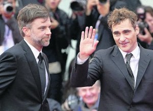 El actor Joaquin Phoenix saluda al público de la Mostra en compañía de Paul Thomas Anderson. ::                             REUTERS