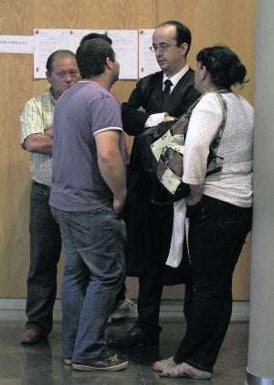 El acusado, al fondo, flanqueado por su letrado y familia. ::
M. ROJAS