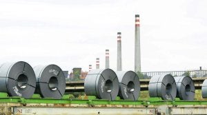 Un tren que transporte bobinas pasa por delante de las baterías de Arcelor en Avilés. ::                             MARIETA A. SANJURJO