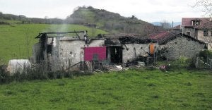 Los restos de la vivienda en la que vivía la familia en la localidad de Baselgas, aún humeantes ayer por la mañana. ::                             JOSÉ LUIS CEREIJIDO / EFE