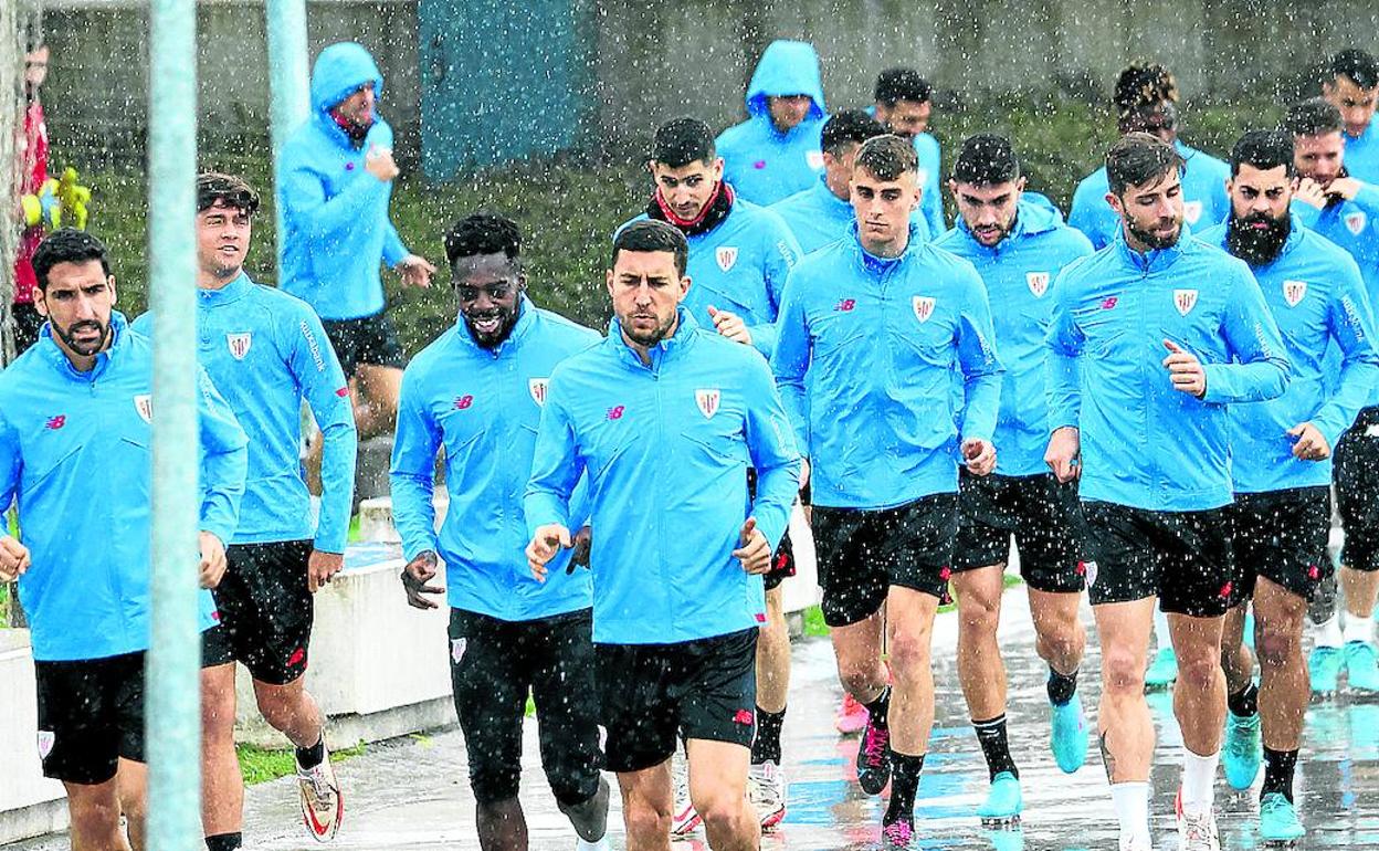 Los jugadores del Athletic se dirigen a entrenar bajo la lluvia de ayer jueves. 
