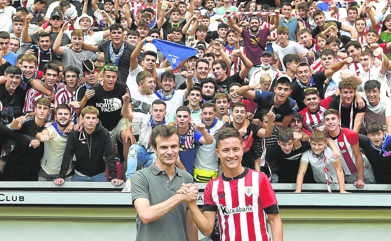 Puesta en largo con público. El presidente Jon Uriarte y Ander Herrera unen sus manos en el acto de presentación celebrado ayer en San Mamés ante 2.300 aficionados. 