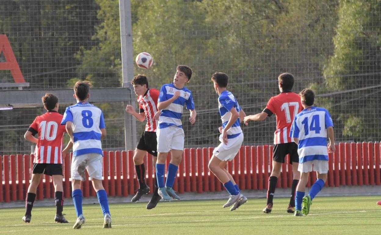 Jugadores del Athletic y del Bizkerre pugnan por un balón aéreo en el partido de Lezama.