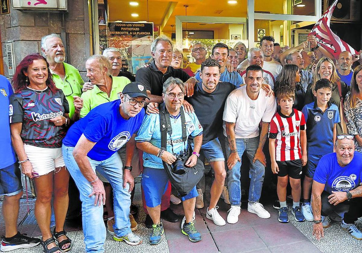 Jugadores y aficionados del Athletic posan juntos en la foto delante de la sede de la peña en honor de Mikel Vesga en Vitoria.