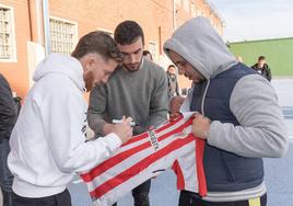 Muniain y Lekue firman una camiseta del Athletic a uno de los reclusos en el patio de la cárcel.