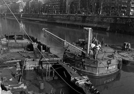 La gabarra del Athletic ayuda a sacar a flote el Consulado de Bilbao, que se hundió en las inundaciones