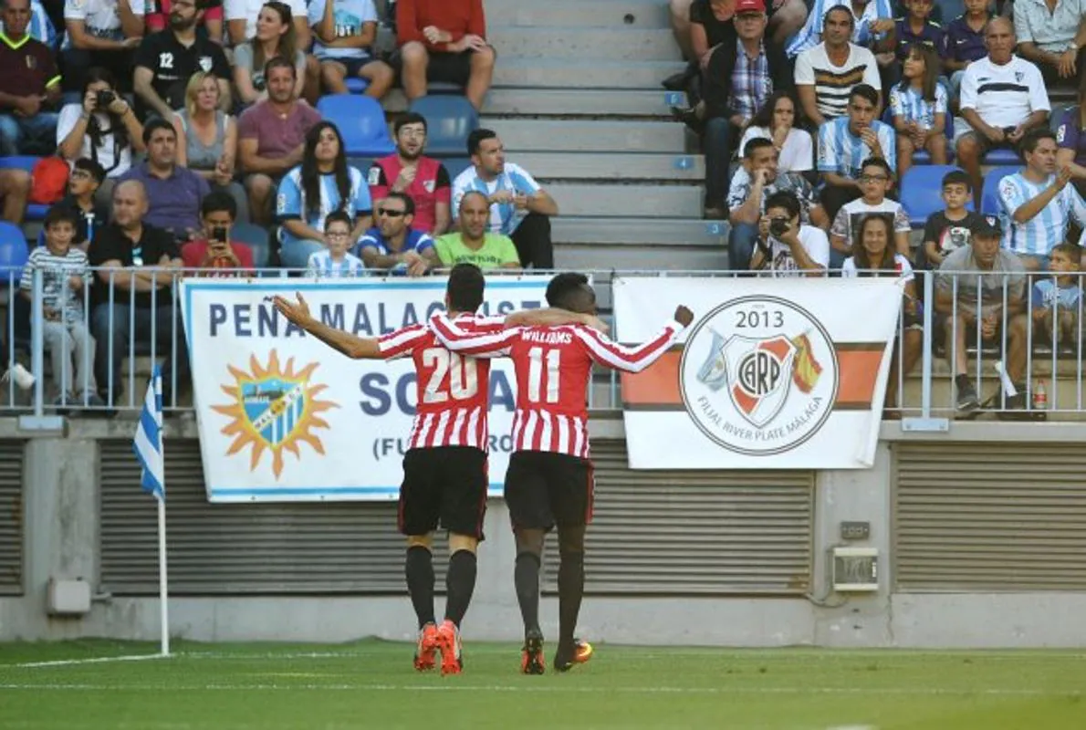 Aduriz y Williams celebran el 0-1 ante una de las gradas de La Rosaleda ajena a los gritos de «puto vasco el que no bote».
