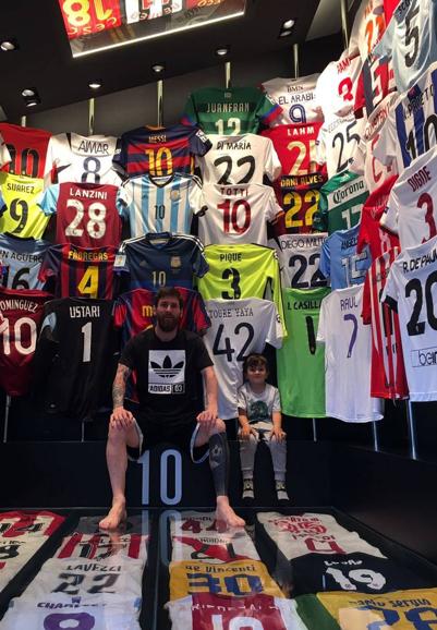 Leo Messi y su hijo, rodeados de camisetas.