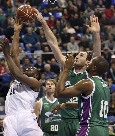 El pívot montenegrino del Unicaja, Vladimir Golubovic (2d), tapona al ala-pivot norteamericano del Bilbao Basket , Latavious Williams.