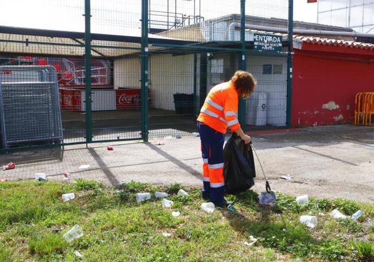 Una operaria de limpieza retiraba todavía hoy la basura que estaba concentrada en el acceso al Fondo Norte del estadio.