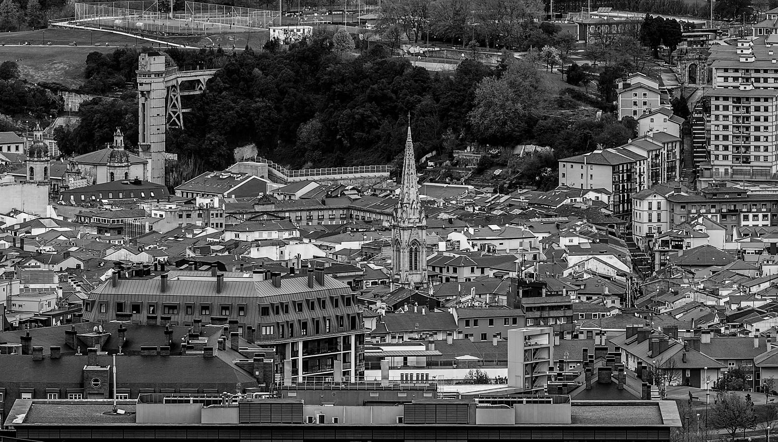 Vista del Casco Viejo, desde la subida al Pagasarri, con la torre de la catedral de Santiago sobresaliendo y los campos de fútbol de Mallona al fondo.