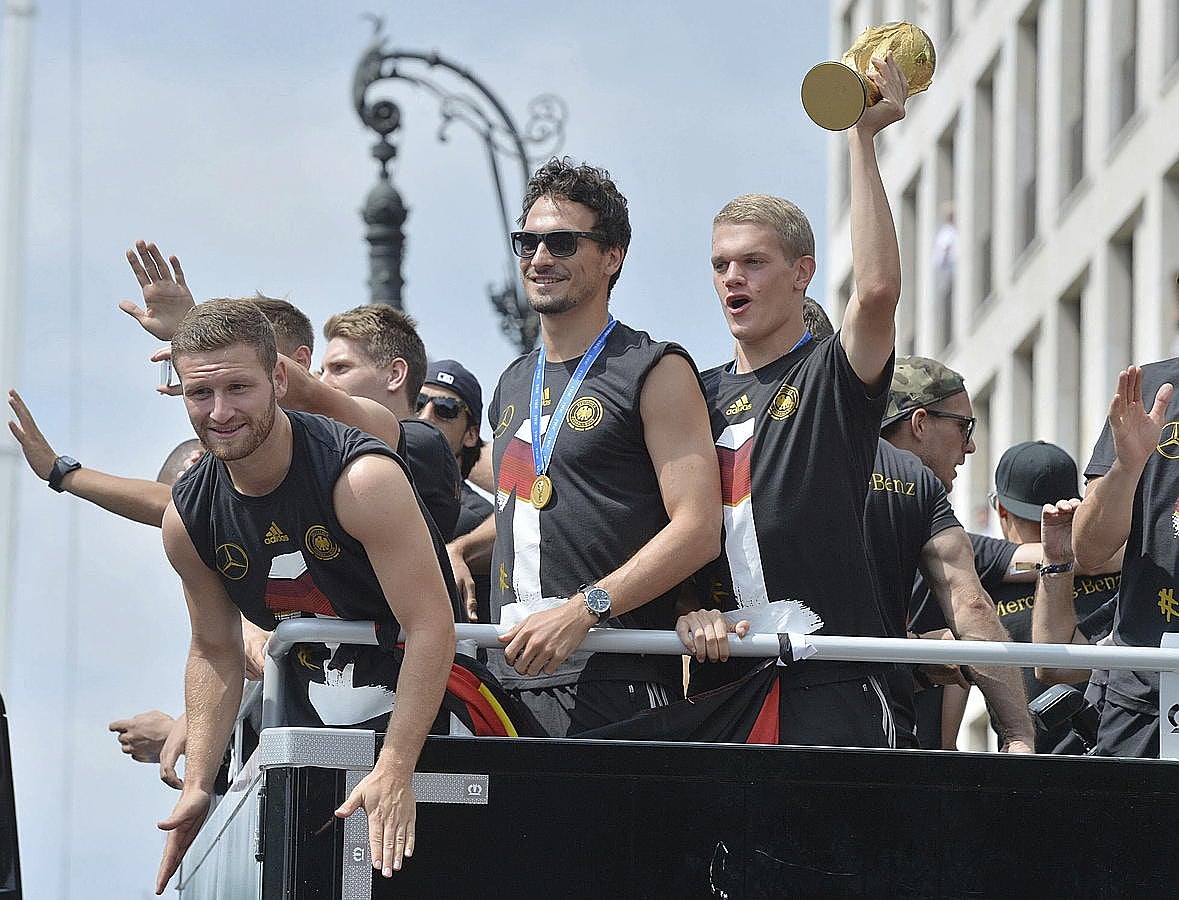 LA SELECCIÓN ALEMANA CELEBRA LA COPA DEL MUNDO CON MILES DE AFICIONADOS. Shkodran Mustafi (i-d), Mats Hummels y Matthias Ginter celebran la Copa del Mundo de la FIFA con cientos de miles de aficionados a su llegada a la Puerta de Brandeburgo a bordo de un autobús sin techo, en Berlín.