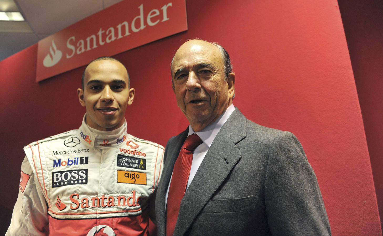 El presidente del Banco Santander, Emilio Botín (d), acompañado del piloto de Fórmula Uno, Lewis Hamilton, inaugura la primera sede de la entidad en el mercado británico, en Londres.