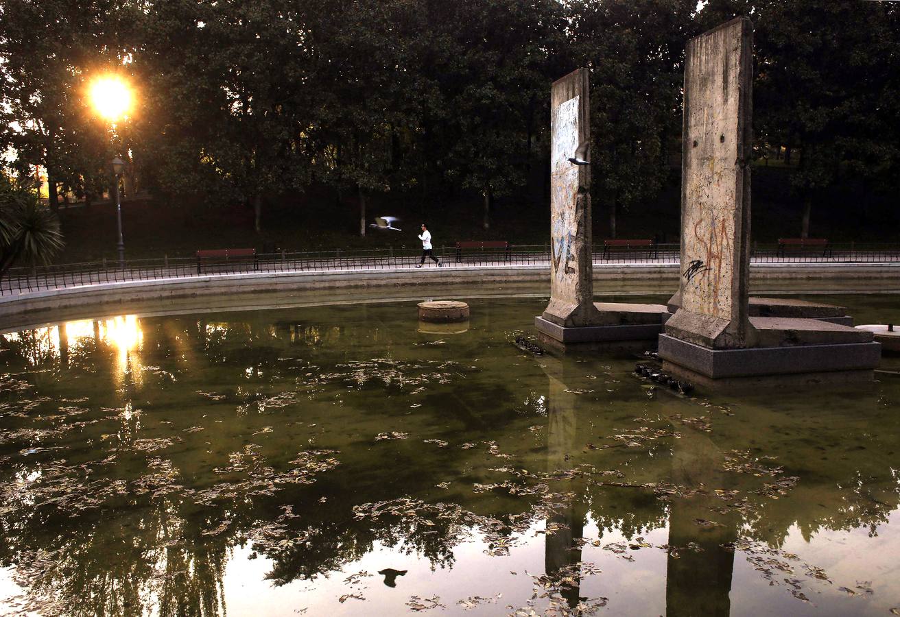 Una mujer, junto a los tramos del Muro de Berlín instalados en el parque de Berlín de Madrid.