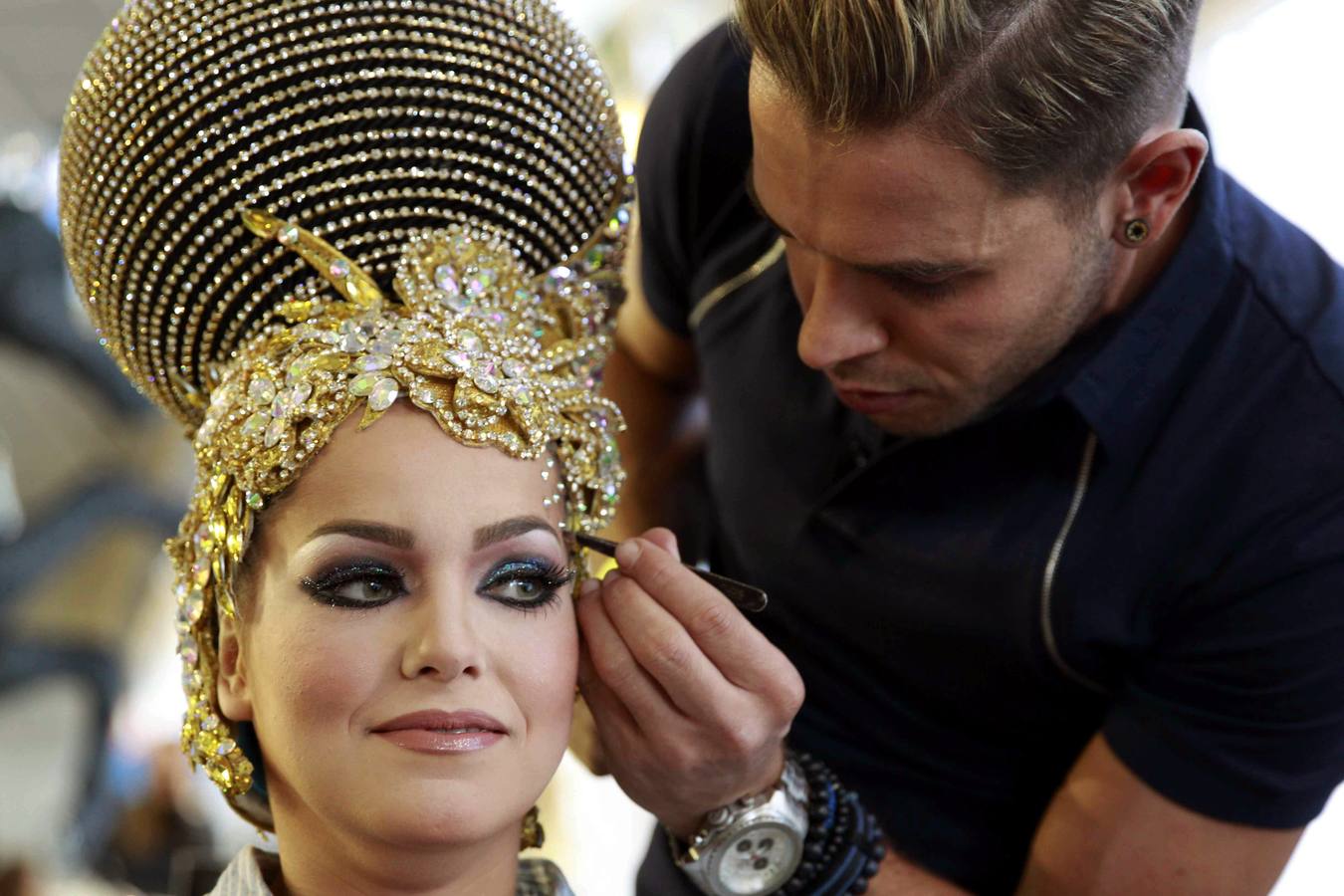 Una de las catorce aspirantes a Reina del Carnaval 2015 de la capital tinerfeña es maquillada antes de comenzar la gala de elección de Reina.