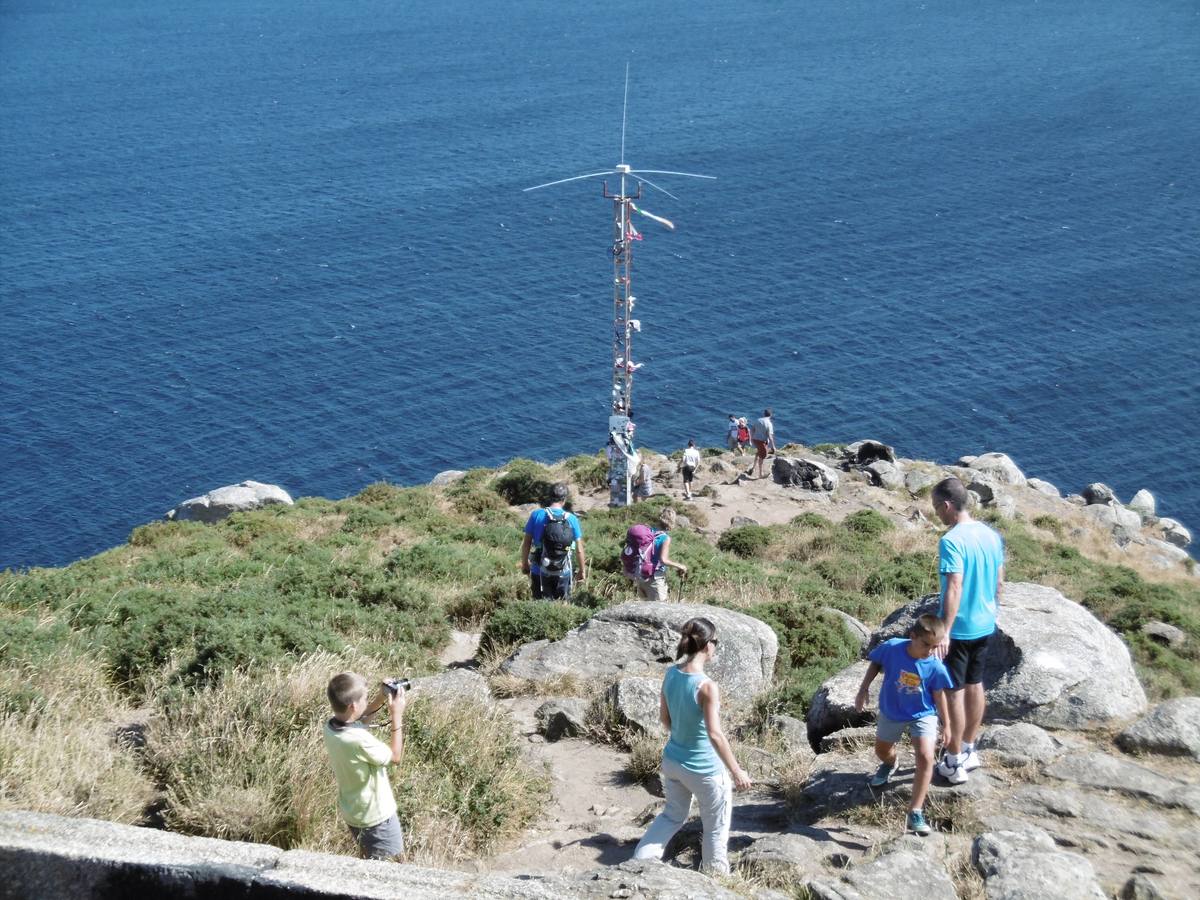 Finisterre. Turistas y peregrinos bajan por el acantilado.. 