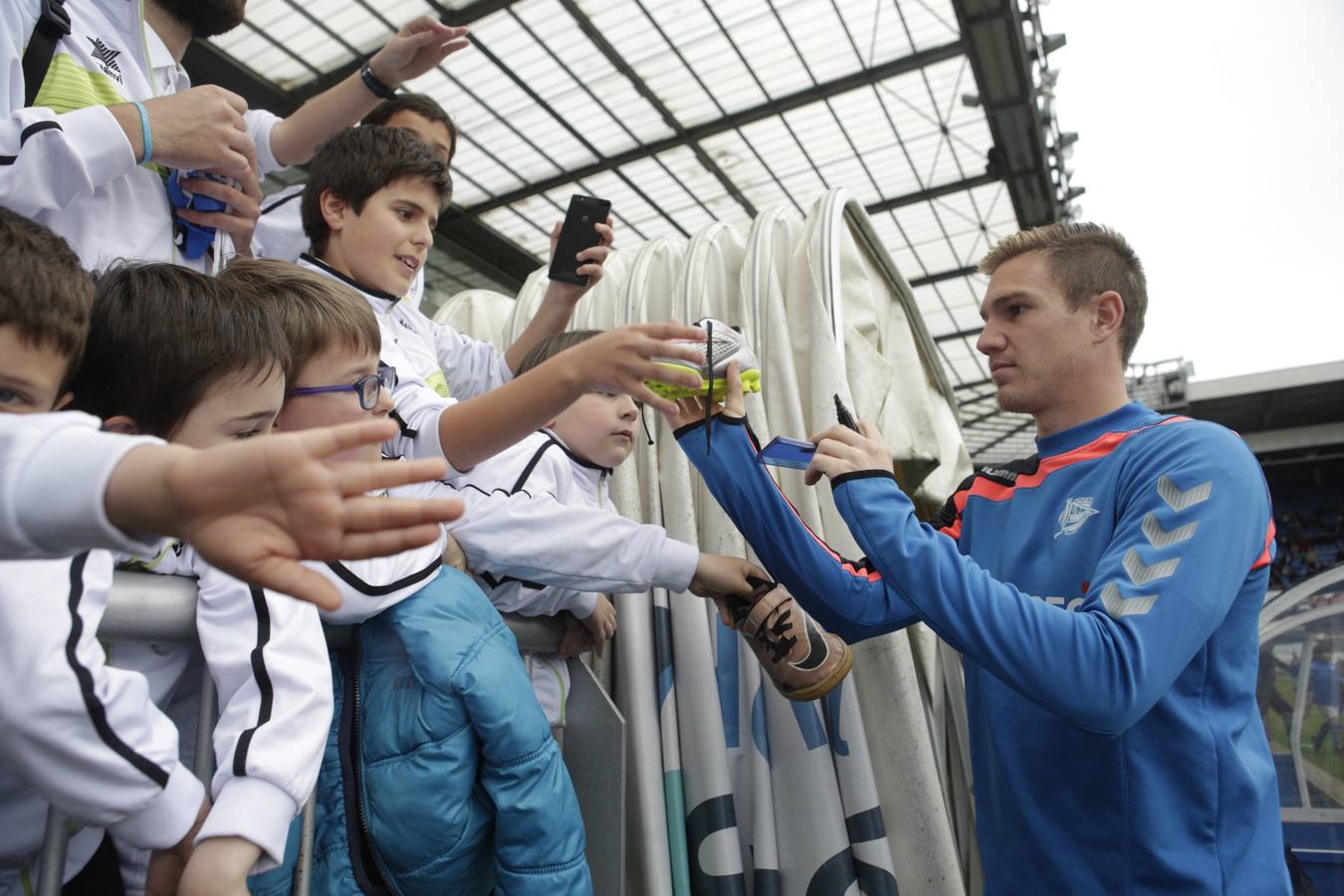 Los jugadores saludan y firman autógrafos a los niños