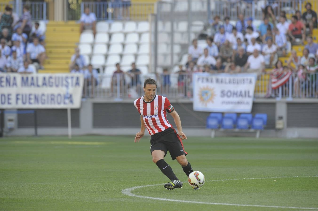 El capitán rojiblanco pasa el balón a un compañero durante un partido de Liga en La Rosaleda en agosto de 2014