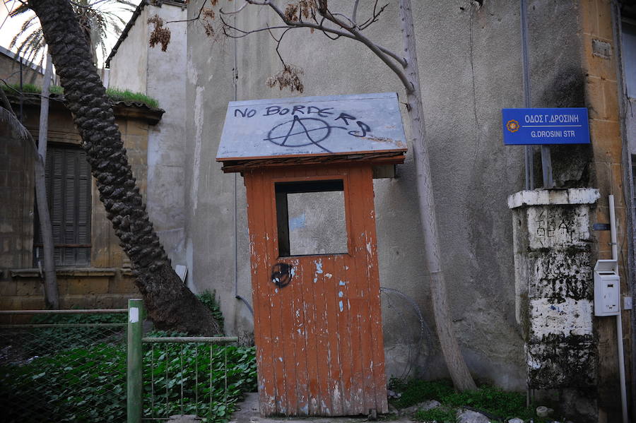 Una garita con una pintada que rechaza el muro que separa a la ciudad.