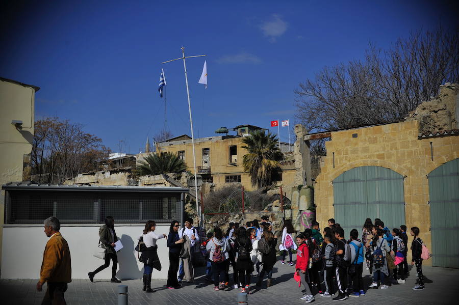 Un grupo de turistas se acercan al muro que separa la capital.