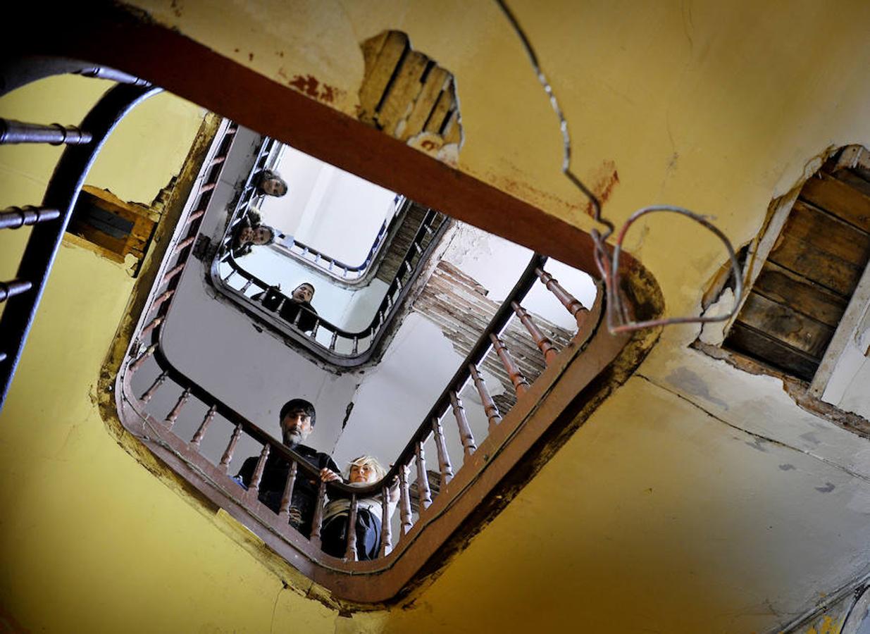 Pascual Jiménez y su mujer, Asunción Muza, se asoman al hueco de la escalera, rodeada de socavones y con los listones de madera a la vista.