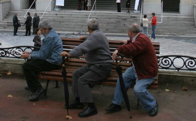 Tres jubilados sentados en un banco en Bilbao.