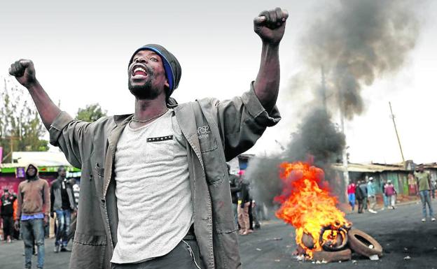 Un partidario del líder opositor Raila Odinga protesta junto a una barricada en el suburbio de Kibera, en Nairobi.