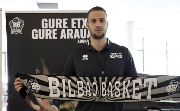 El nuevo jugador del RETAbet Bilbao Basket, con la bufanda del equipo. 