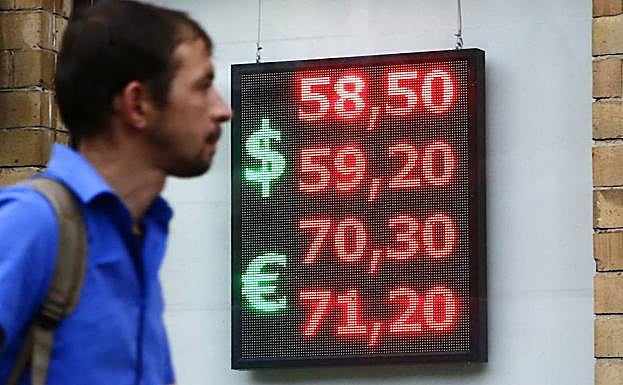 Un hombre pasa junto a un panel electrónico en el que muestra el tipo de cambio en Moscú este martes.