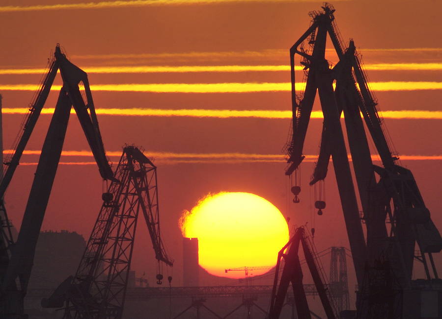 Las grúas de la Naval de Sestao se recortan contra el sol durante el crepúsculo del atardecer en 2004. 