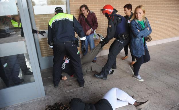 La mujer desahuciada, tumbada en primer término, durante la actuación policial.