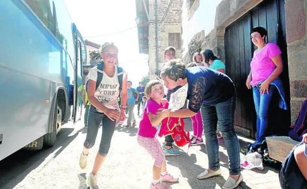 Las madres reciben en la parada del autobús a sus hijos, que no tardan en desperdigarse por el pueblo.