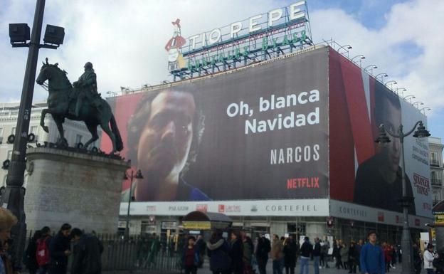 Cartel de Netflix en la Puerta del Sol , en el que aparece el protagonista de la serie 'Narcos', deseando una 'blanca Navidad'.