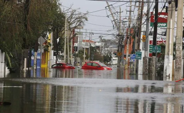 Dos coches flotan en una calle totalmente inundada en San Juan (Puerto Rico). 